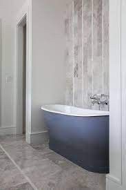 After the tiles are set, you need to add grout gently on the surface with the help of a trowel. Gray Bathtub With Gray Vertical Tiles Contemporary Bathroom