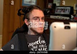 Valle Crusis, North Carolina, USA. 12th Sep, 2022. Luke Wilcox, 22, sits in  his wheelchair in his parent's rural home to watch television and type