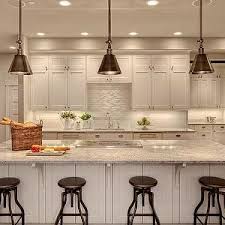 Studio 212 Kitchens White Shaker Cabinets Kitchen Island Tan Walls Paneled Fridge Appliances Kashmir White Kashmir White Granite Contemporary Kitchen