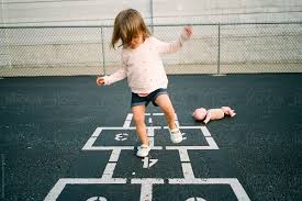 If you prefer to play hopscotch inside, masking tape instead of chalk will do. Child Playing Hopscotch By Maria Manco