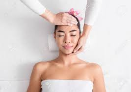 Beauty And Wellness. Young Asian Woman Enjoying Face Lifting Massage  Treatment In Spa Salon, Pretty Korean Lady With Flower In Hair Relaxing On  Table With Closed Eyes, Top View With Copy Space