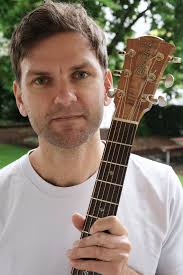 Guitar student plays percussive acoustic guitar