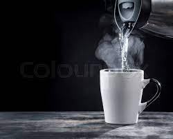 Pouring hot water into into a cup on a black background | Stock image |  Colourbox