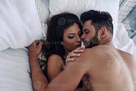 Hotter and hotter. Top view of beautiful young couple making love while  lying in the bed 13572862 Stock Photo at Vecteezy