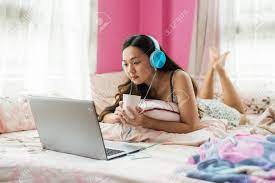 Maybe you would like to learn more about one of these? Attractive Asian Beautiful Woman In Bed Watch Online Movie From Laptop Computer And Drink Hot Coffee In Morning Leisure Lifestyle By Enjoying Music Video From Internet Website At Home Bedroom Stock Photo