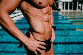 41 chest, 33 waist, 40 hip, 22 cross shoulder, 35 high. Male Swimmer With Abdominal Muscles Standing At Poolside On Sunny Day Stockphoto