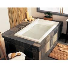 Oval soaking tub with chrome corner faucet is seated inside patterned tile enclosure between twin this soaking tub employs a whirlpool system, for a massaging experience. The 8 Best Small Bathtubs Of 2021