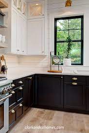 Modern kitchen cabinets coupled with open faced upper cabinets and beadboard backsplash make this kitchen look open, airy, and clean. Black Windows And Lower Base Cabinets Accent The Upper White Cabinets And Shipl Kitchen Cabinets Black And White Modern Farmhouse Kitchens Black Lower Cabinets