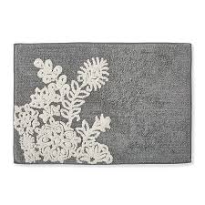 A chic farmhouse bathroom with white plank walls, stained wooden shelves, a white vanity and a metal sink. One Home Farmhouse Floral Textured Bath Rug