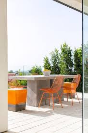 Contemporary Deck Is Fitted With A Concrete Block Dining Table Seating Orange Metal Dining Cha Concrete Outdoor Dining Table Patio Design Outdoor Dining Chairs