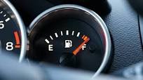 Car fuel gauge needle rising to full after filling up tank. Close-up of  dashboard instrument panel showing gas level increasing. Refueling concept