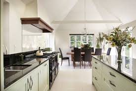 The ceiling is made up of open beams, above which you can detect a stripy, green pattern. Tempered Glass Behind Cooktop