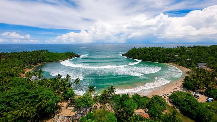 Hiriketiya Beach hidden horseshoe bay surf cafes yoga retreats crystal clear water steep access road south coast Sri Lanka