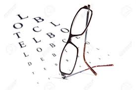 Reading Glasses Balanced On An Opthalmology Vision Testing Chart
