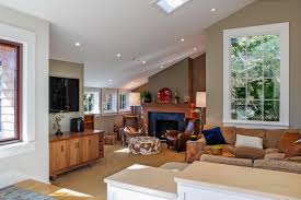 The fireplace acts as a pivot point for the design, as it faces the bay view while its backside becomes the crossing main hallway and a shaft of light becomes the center. Neutral Transitional Living Room With Slanted Ceiling And Skylight Hgtv