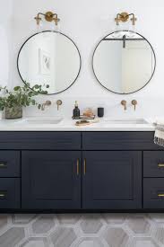 Navy Double Vanity Bathroom With Brass Fixtures And Round Mirrors Hexagon Tile Floor Bathroom Vanity Designs Double Vanity Bathroom Bathroom Sconces