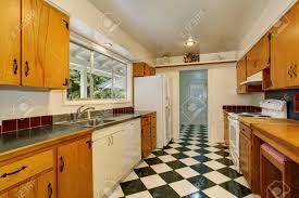 Kitchen floor tile ideas with white cabinets mycoffeepot org. Narrow Kitchen Room Interior With Black And White Tile Floor Light Brown Cabinets And White Kitchen Appliances Stock Photo Picture And Royalty Free Image Image 60410202