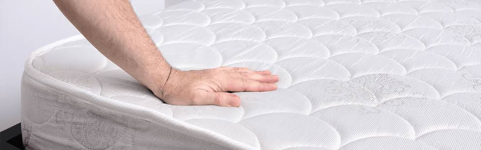 Close-up comparison of old mattress body impression and flat new mattress surface