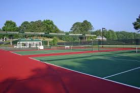 Close up of tennis racquet and balls on the clay tennis court. Tennis Court Construction Installation Cj Sports