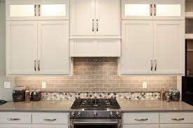 The center arrangement above the stove has a decorative iron design in the middle. White And Grey Tile Backsplash Glossy Beige Stone Tile Accent Wall Tile Accent Wall Gray Tile Backsplash White Bathroom Decor
