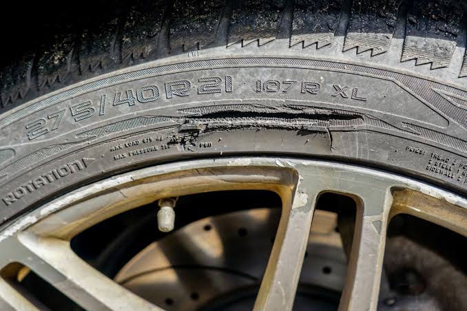 Close up view of a car tire showing the tread and sidewall edge