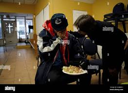Peter Prevost, center, wipes his tears as pastor Dorothy Lewis prays at  Potter's Place Mission