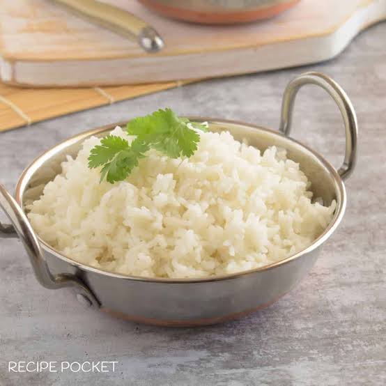 Measuring cup showing the correct water to rice ratio for fluffy kabsa rice on a kitchen counter