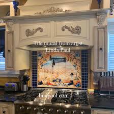 Beautiful italian tile backsplash mural of a kitchen window featuring a still life of olive tiles, grapes, bread, cheese, garlic, olive oil, olives, rosemary, lemons and a hummingbird by american artist linda paul. Italian Tile Murals Tuscan Backsplash Tiles