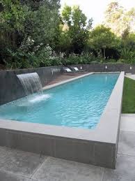 A Raised Lap Pool With A Water Fall Is The Main Feature Of The Back Yard The Raised Edge Wo Pool Landscape Design Pool Landscaping Above Ground Swimming Pools