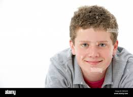 Young fourteen year old teenage girl sits in her bedroom applying makeup in  a mirror in preparation to go out Stock Photo