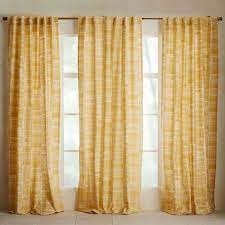 These sheer white patterned curtains look great against the sunny yellow walls in this eclectic dining room design. 12 Reasons To Give Patterned Curtains A Chance Yellow Curtains Living Room Mid Century Modern Curtains Modern Window Treatments