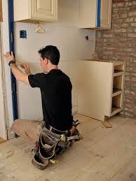 The kitchen installers begin by using a level to mark the locations of the wall and base cabinets (image 1). How To Install Kitchen Cabinets Installing Kitchen Cabinets Installing Cabinets Kitchen Cabinets