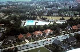 luchtfoto van woudweg met op de achtergrond openlucht zwembad het woudven holland zwembad stad