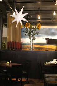 A View Of Empty Table Settings With A Vase Full Of Sunflowers And Other Decorations On The Walls Philadelphia Restaurants Table Settings Decor