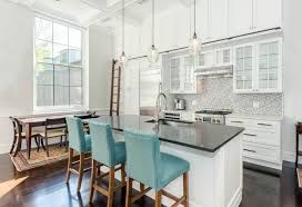 The island peninsula is accommodated by the enlarged cased opening to the living room, which has been painted a stark black to contrast against white walls. White Kitchen Cabinets With Dark Countertops Designing Idea