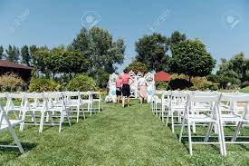 The stacking wedding chairs can easily be move from one place to another. Rows Of White Folding Chairs On Lawn Before A Wedding Ceremony In Summer Girl Organizers Suggest A Final Order Before The Guests Arrive Foto Royalty Free Gravuras Imagens E Banco De Fotografias