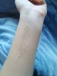 40 Subtle White Ink Tattoo Designs And Ideas Greenorc White Feather Tattoos White Ink Tattoo Feather Tattoos