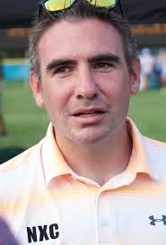 Cross country runners dash under the lights at Ford Field in Livonia