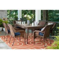 What is the cheapest option available within patio dining sets? Hampton Bay Cambridge 7 Piece Brown Wicker Outdoor Patio Dining Set With Cushionguard Midnight Navy Blue Cushions 65 7148b7 The Home Depot Patio Dining Set Outdoor Patio Dining Sets Outdoor Patio Dining