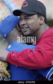 Jose Rijo of the Cincinnati Reds hugs a member of the Los Angeles Dodgers  before a 2002 MLB season game at Dodger Stadium, in Los Angeles,  California. (Larry Goren/Four Seam Images via AP Images Stock Photo