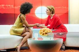 Two Women In A Tv Studio Sitting On Sofas Holding Hands While Talking Tv Talk Show Tv Hand Photography