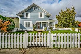 A simple farmhouse with low maintenance landscaping including a well aged split rail fence no more than 3 feet high. 11 Front Yard Fencing Ideas Lawnstarter