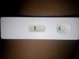 Side view of a sad pregnant teen sitting on her bed after checking a pregnancy test with a dark light in the background. Pregnancy Test Gallery Home Facebook