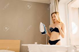 Sexy Blonde Undressed Ironing Clothes In Sunny Morning At Home. Woman  Dressed In Black Bra And Panties. Stock Photo, Picture and Royalty Free  Image. Image 153950212.