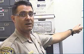 Chaves County Sheriff Britt Snyder points to a box of evidence files, one  of 12 cold cases sheriff's detectives currently have pending. Two of the  oldest cases from 1986 and 1987 are