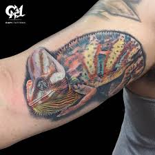 A male panther chameleon is hanging on to a branch. Chameleon Tattoo By Capone Tattoonow