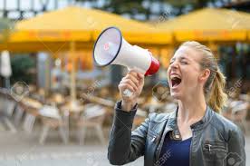 Young Woman Yelling Into A Megaphone Or Bullhorn As She Stands ...