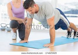 Female Trainer Assisting Man With Push Ups At Gym By Wavebreakmedia Via Shutterstock Fitness Jobs Yoga Trainer Personal Trainer
