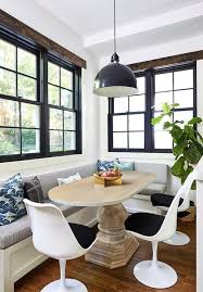 A Wooden Oval Pedestal Dining Table Is Lit By A Black Eugene Pendant And Seats Three Saarnin Tu Dining Table With Bench Pedestal Dining Table Dining Room Combo