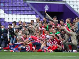 Los aficionados del atlético están celebrando el título del atlético en la fuente de neptuno de madrid. Cn44ocnt8mys M